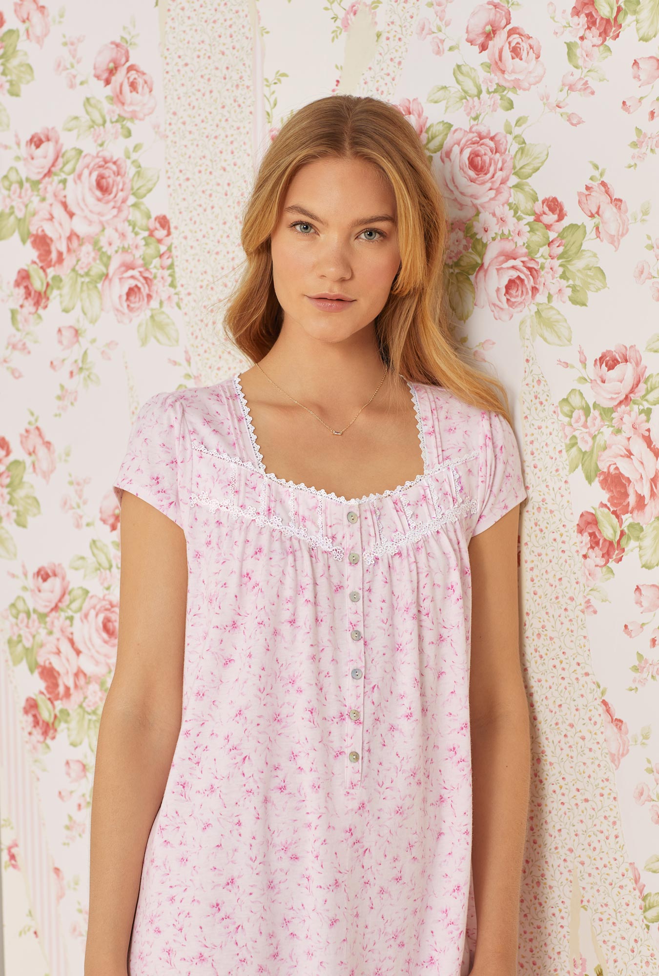 A lady wearing pink cap sleeve short cotton knit nightgown with soft pink floral print.