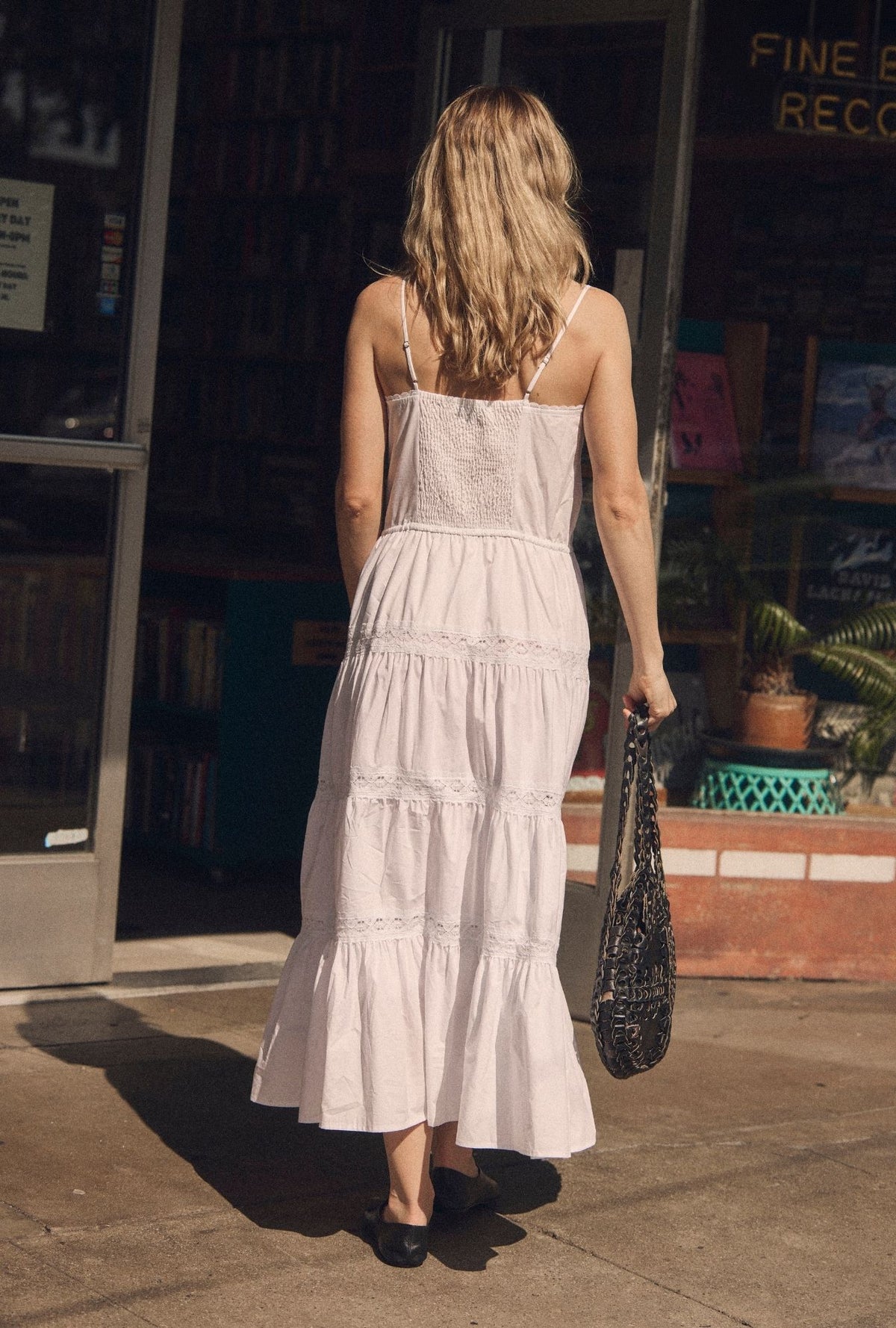 A lady wearing The "Celia" Soft White Cotton Maxi Dress back view