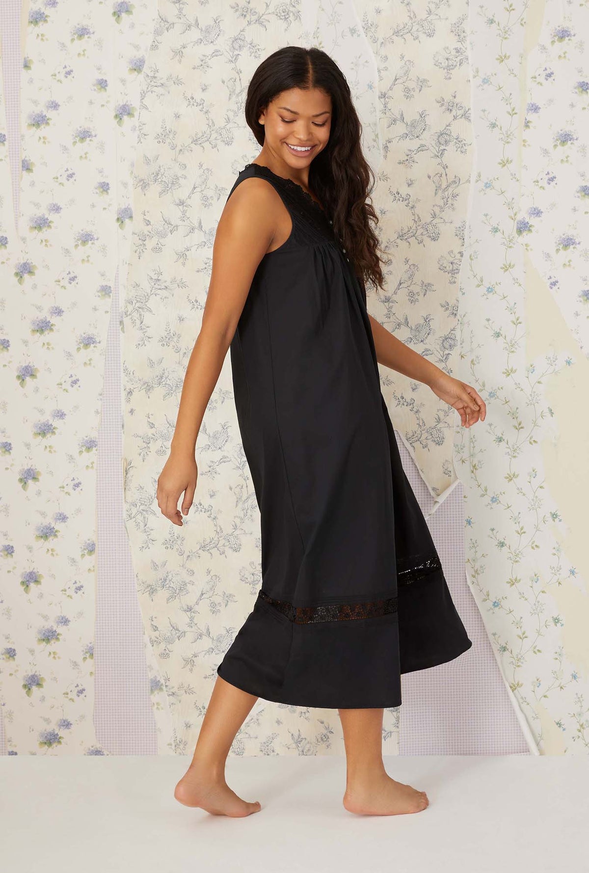 A lady wearing plus size black Portofino Ballet Nightgown in side walking pose with a smile on her face