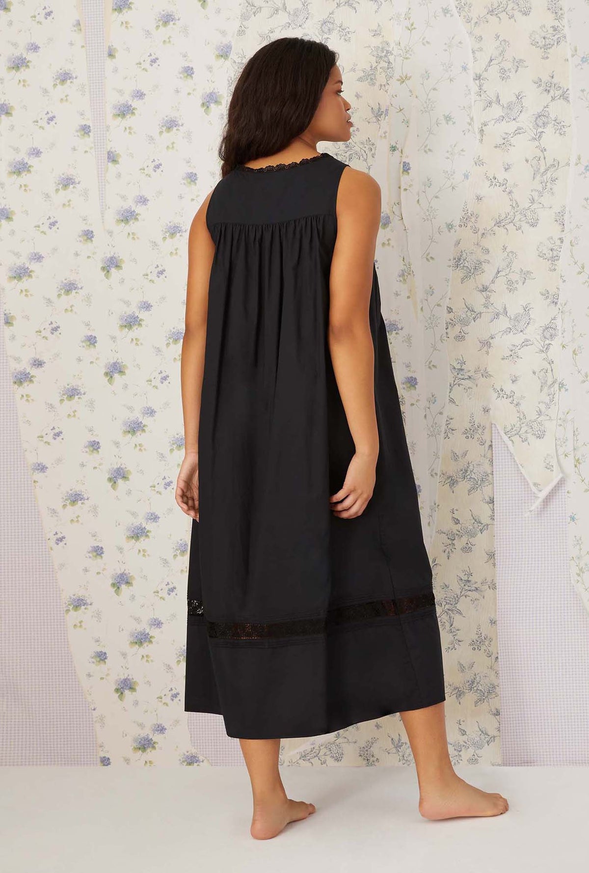 A lady wearing plus size black Portofino Ballet Nightgown in a back view pose