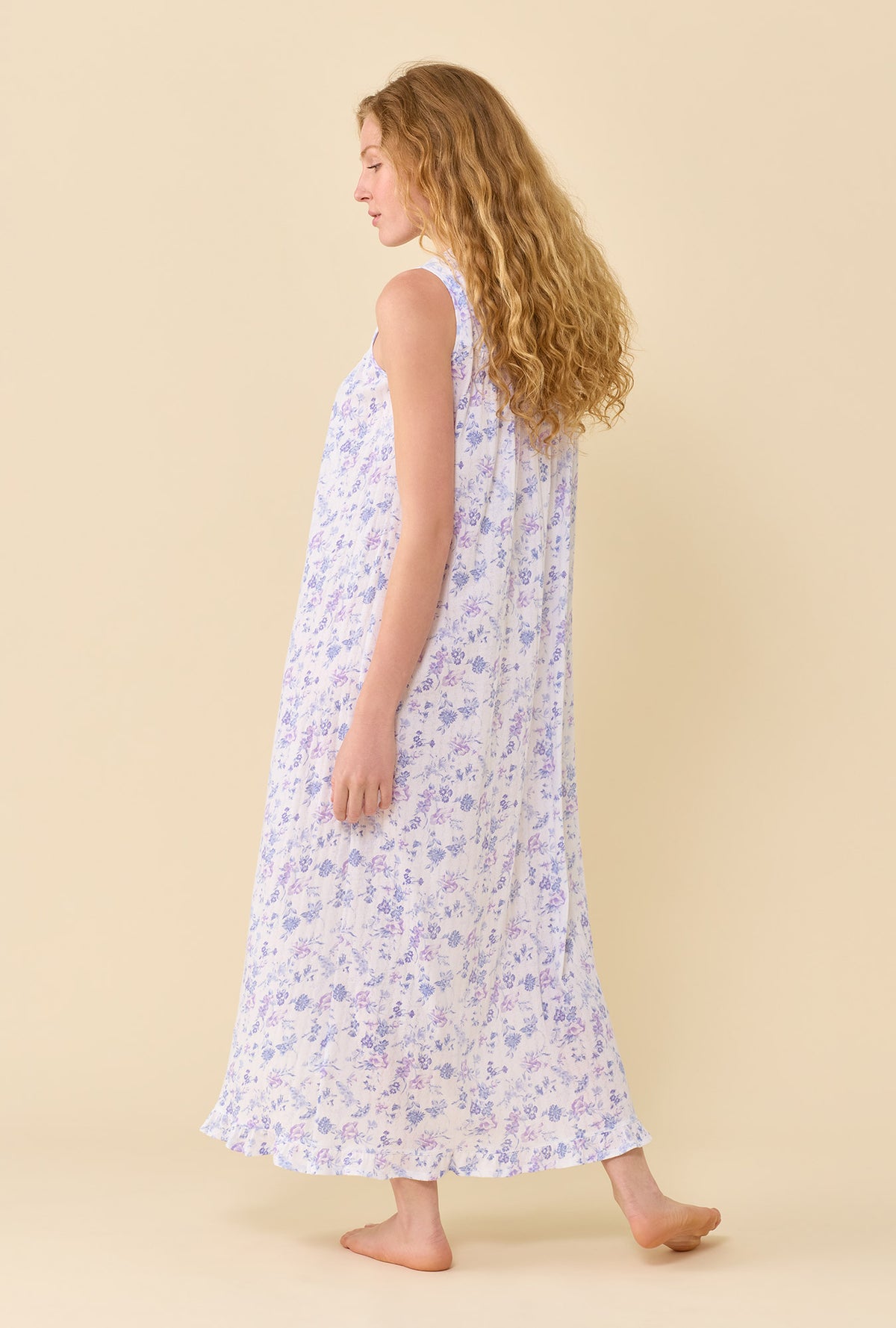 A Lady Wearing The Eileen Wildflower Meadow Nightgown in a back view pose while looking to the side