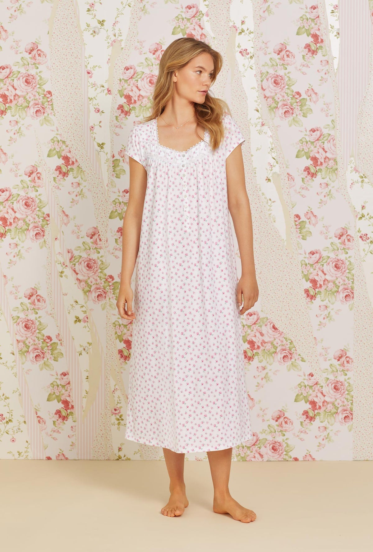 A lady wearing pink cap sleeve cotton knit nightgown with joyful rose print.