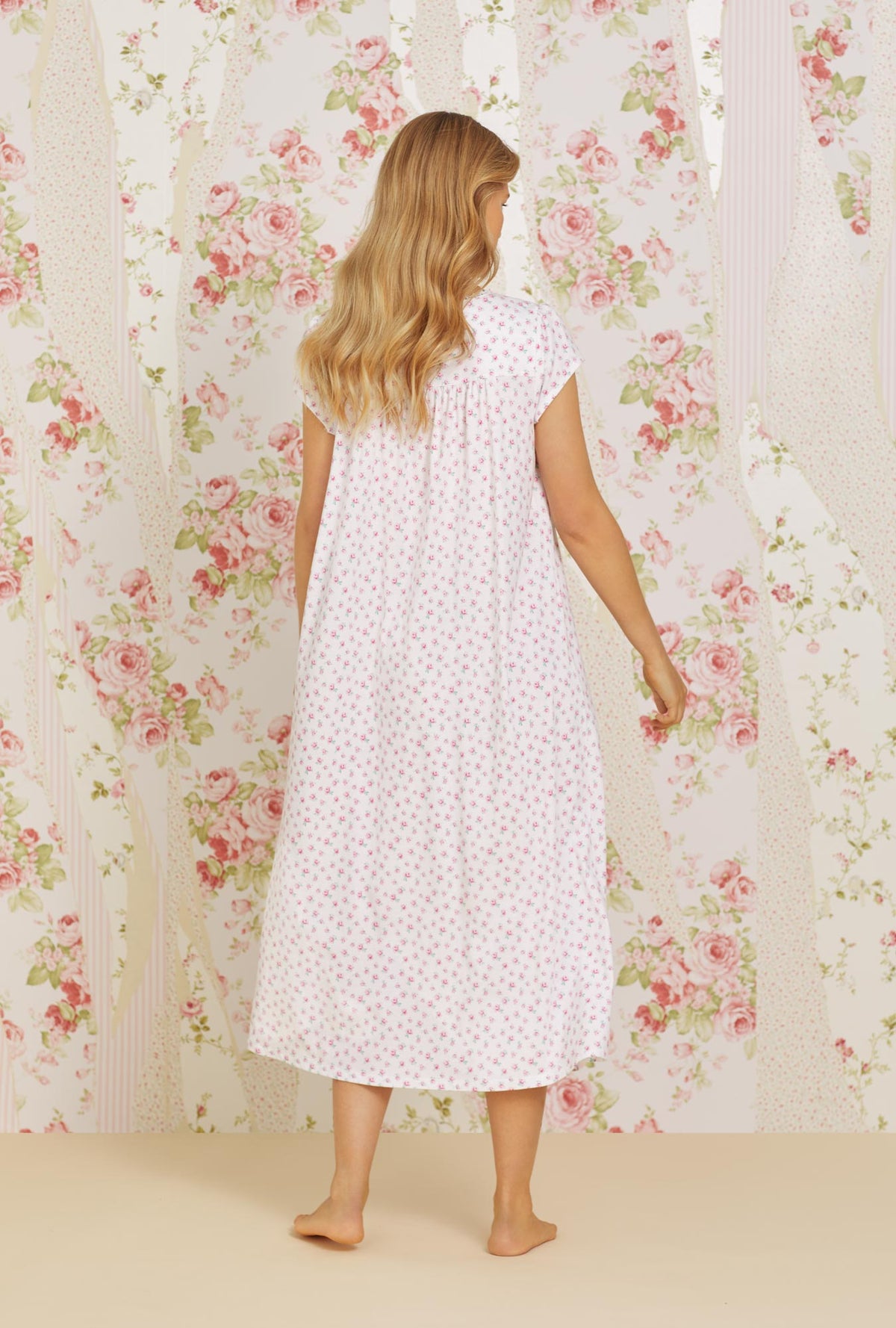 A lady wearing pink cap sleeve cotton knit nightgown with joyful rose print.