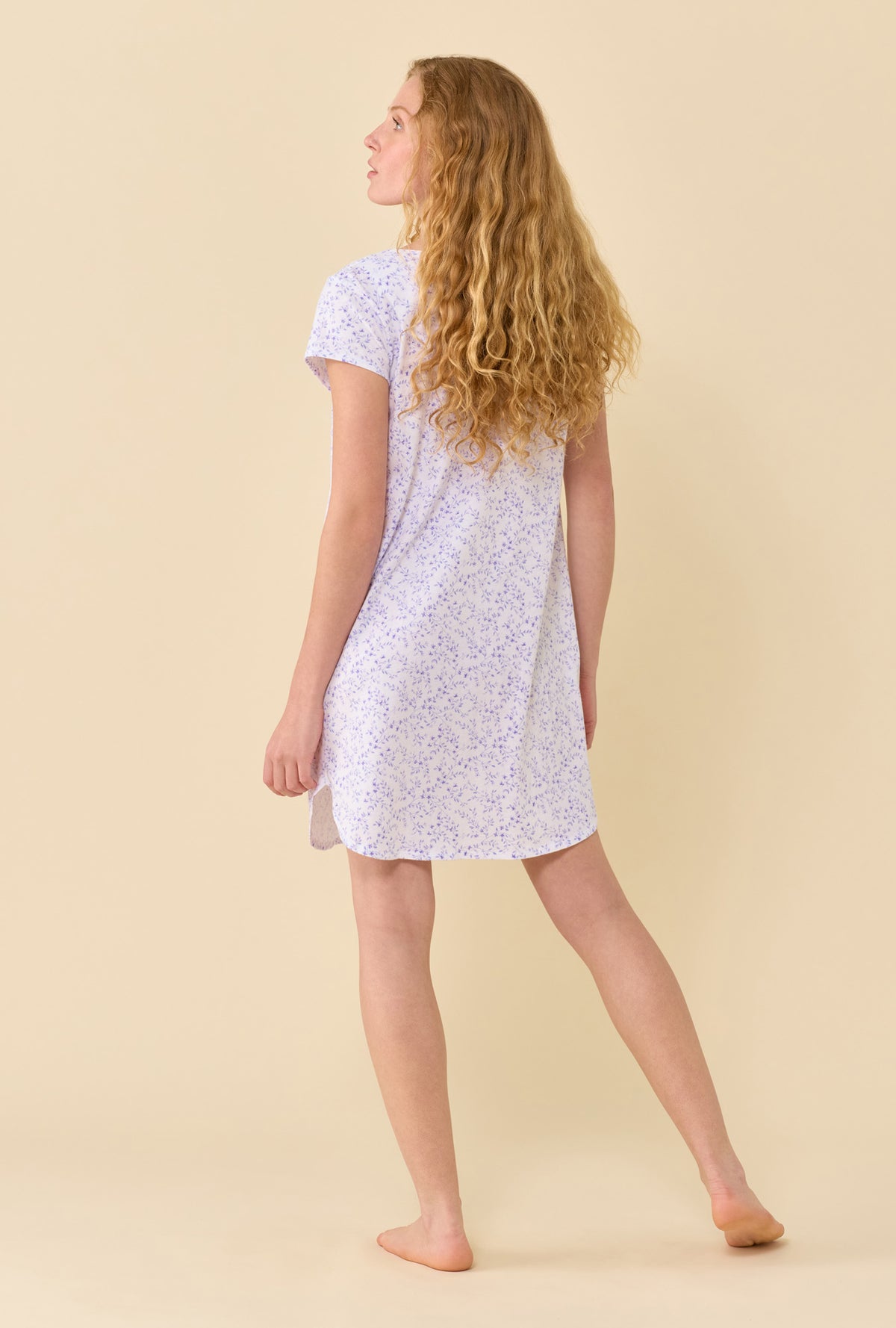 A Lady Wearing Peri Vines Nightshirt in a back view pose with a side angled look