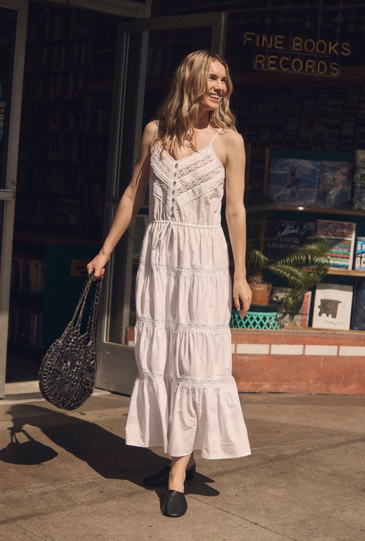 A lady wearing The "Celia" Soft White Cotton Maxi Dress walking