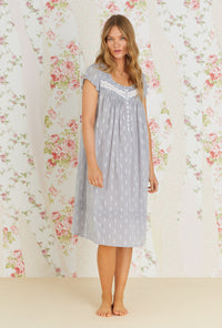 A lady wearing grey cap sleeve waltz nightgown with chambray floral print.