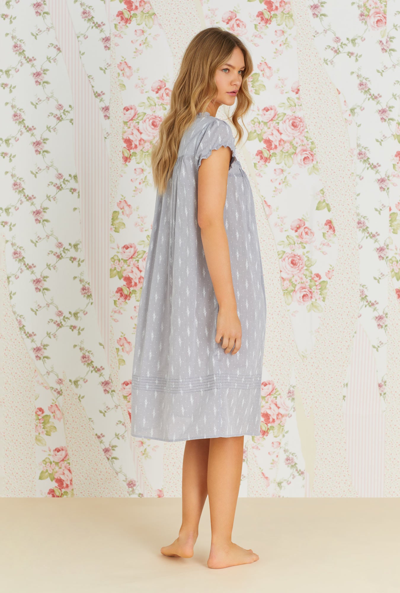 A lady wearing grey cap sleeve waltz nightgown with chambray floral print.