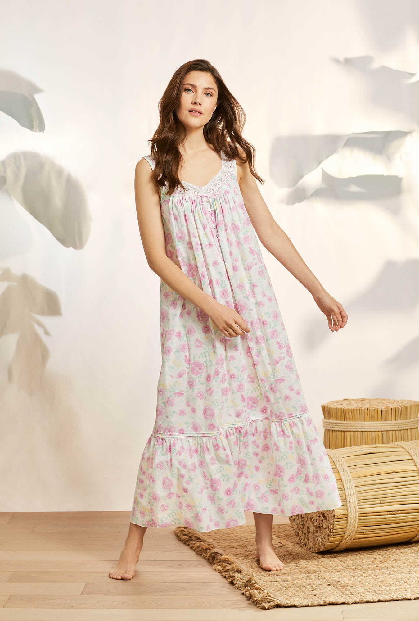 A lady wearing pink sleeveless elizabeth cotton nightgown with wildflower print.