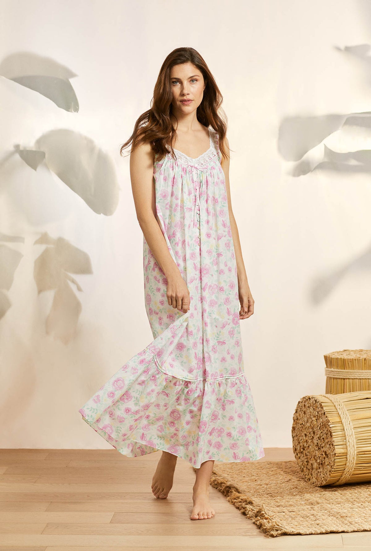 A lady wearing pink sleeveless elizabeth cotton nightgown with wildflower print.