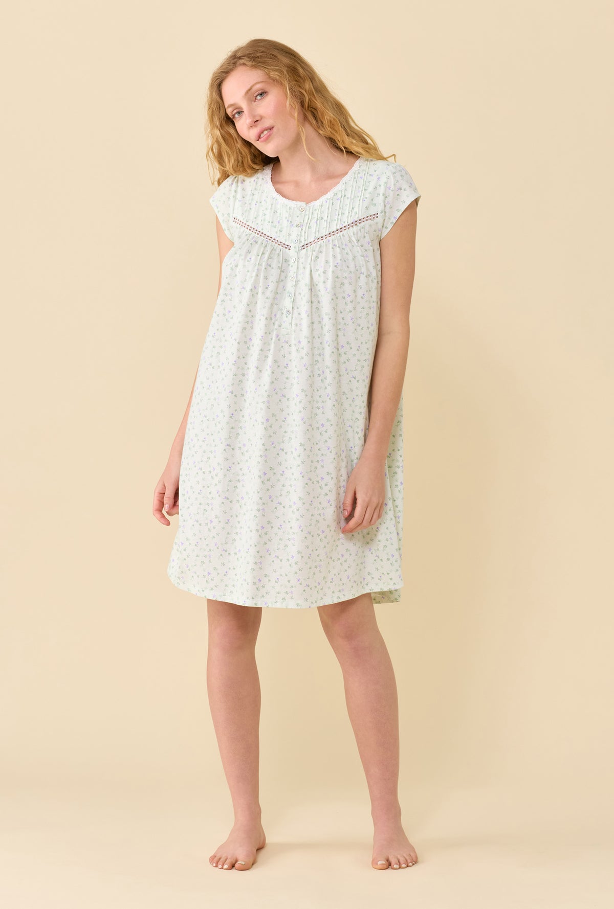 A Lady Wearing Sage Posy Chemise in a front view pose while head tilted gently to her right