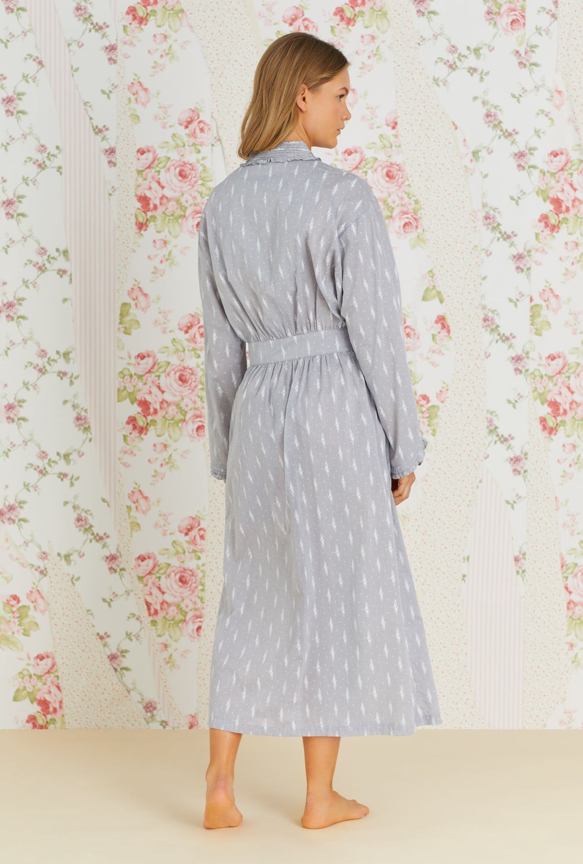 A lady wearing grey long sleeve long wrap robe with chambray floral print.