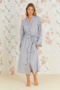 A lady wearing grey long sleeve long wrap robe with chambray floral print.