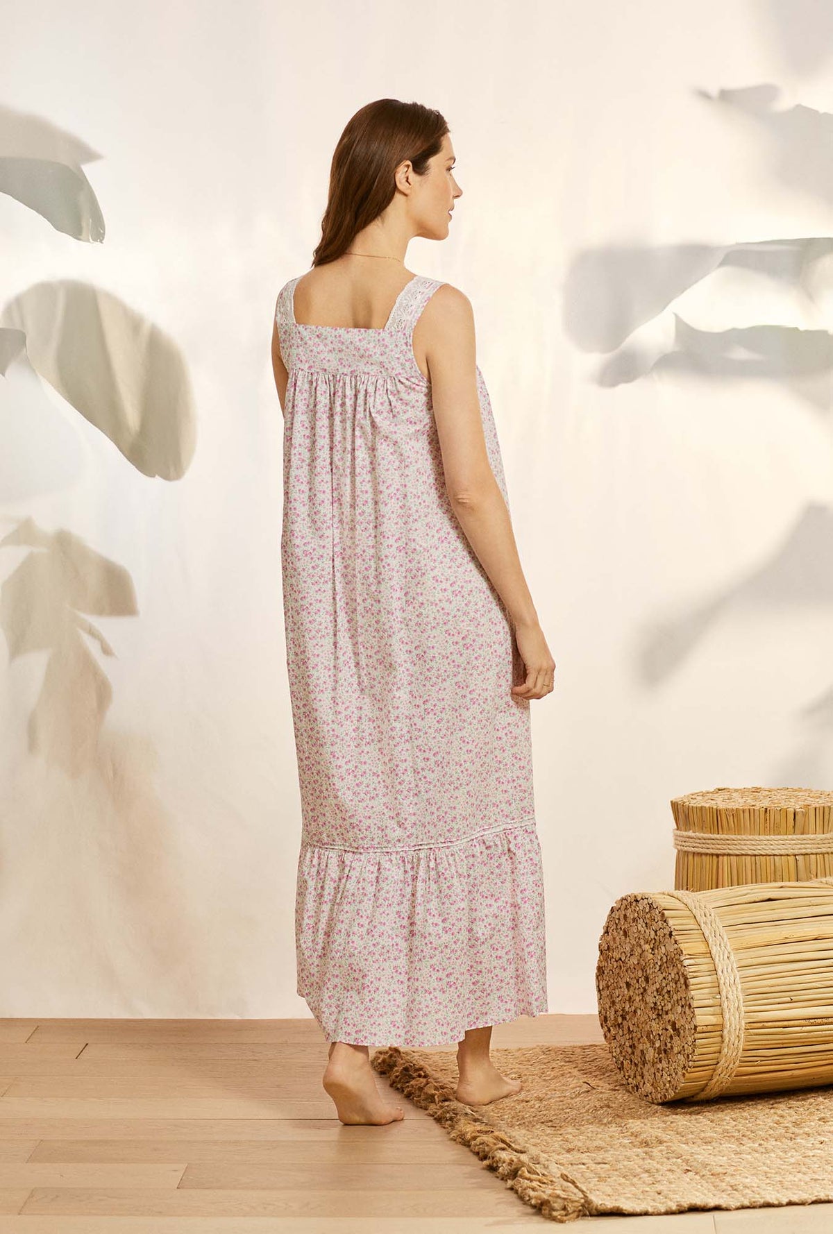 A lady wearing pink sleeveless elizabeth cotton nightgown with vintage rosette print.