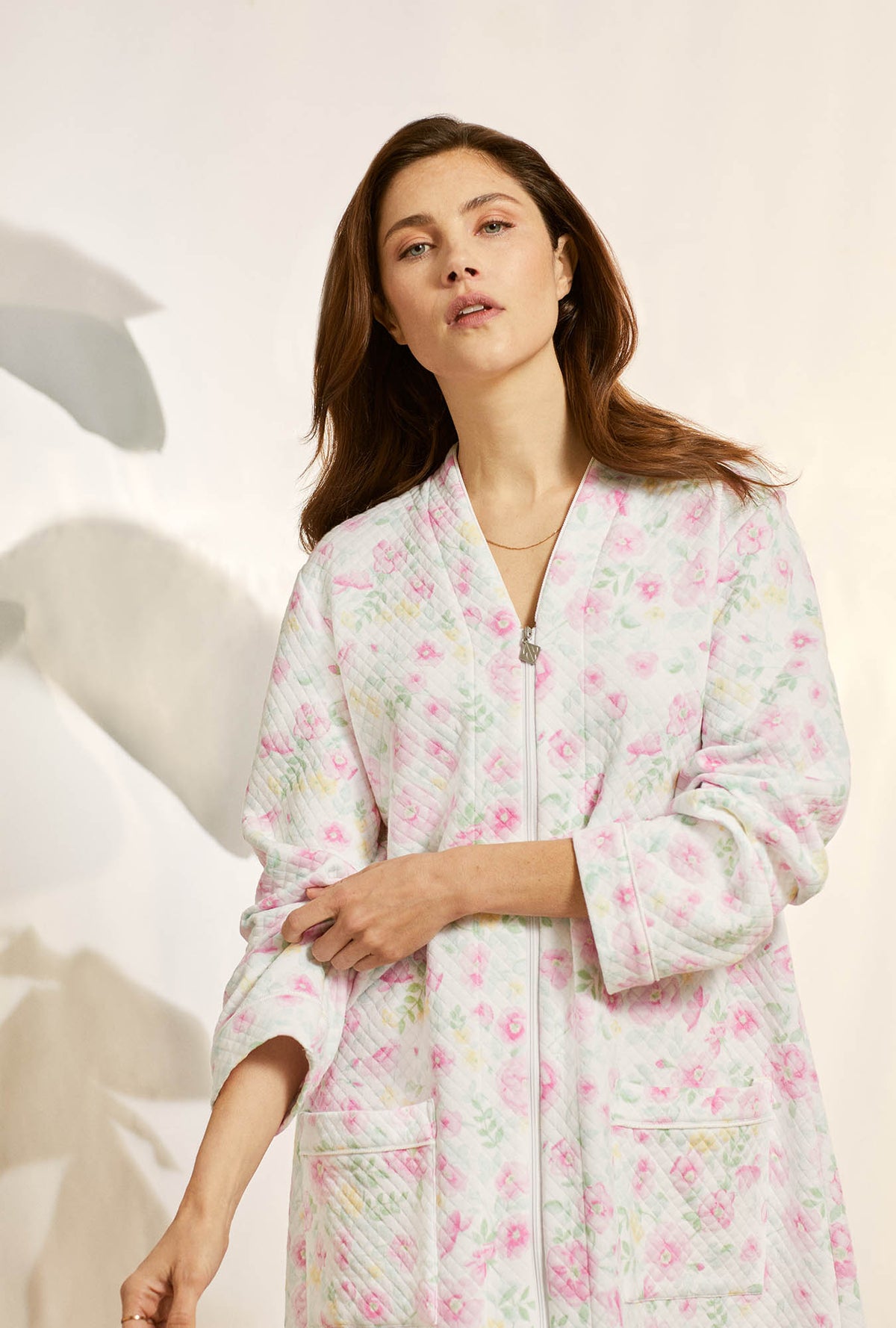 A lady wearing pink long sleeve diamond quilt waltz zip robe with wildflower print.
