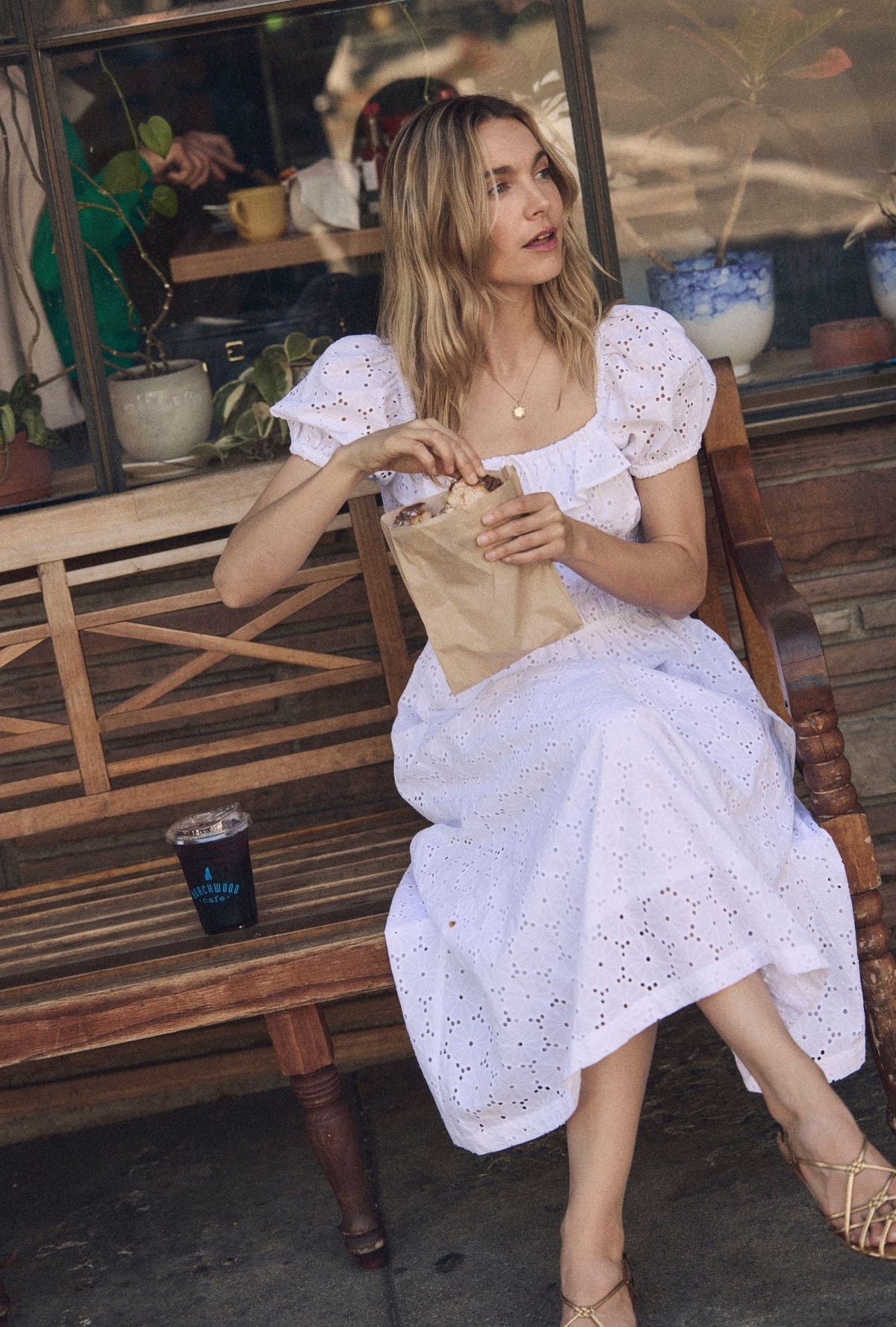 A lady wearing The "Catalina" Soft White Cotton Maxi Dress sitting