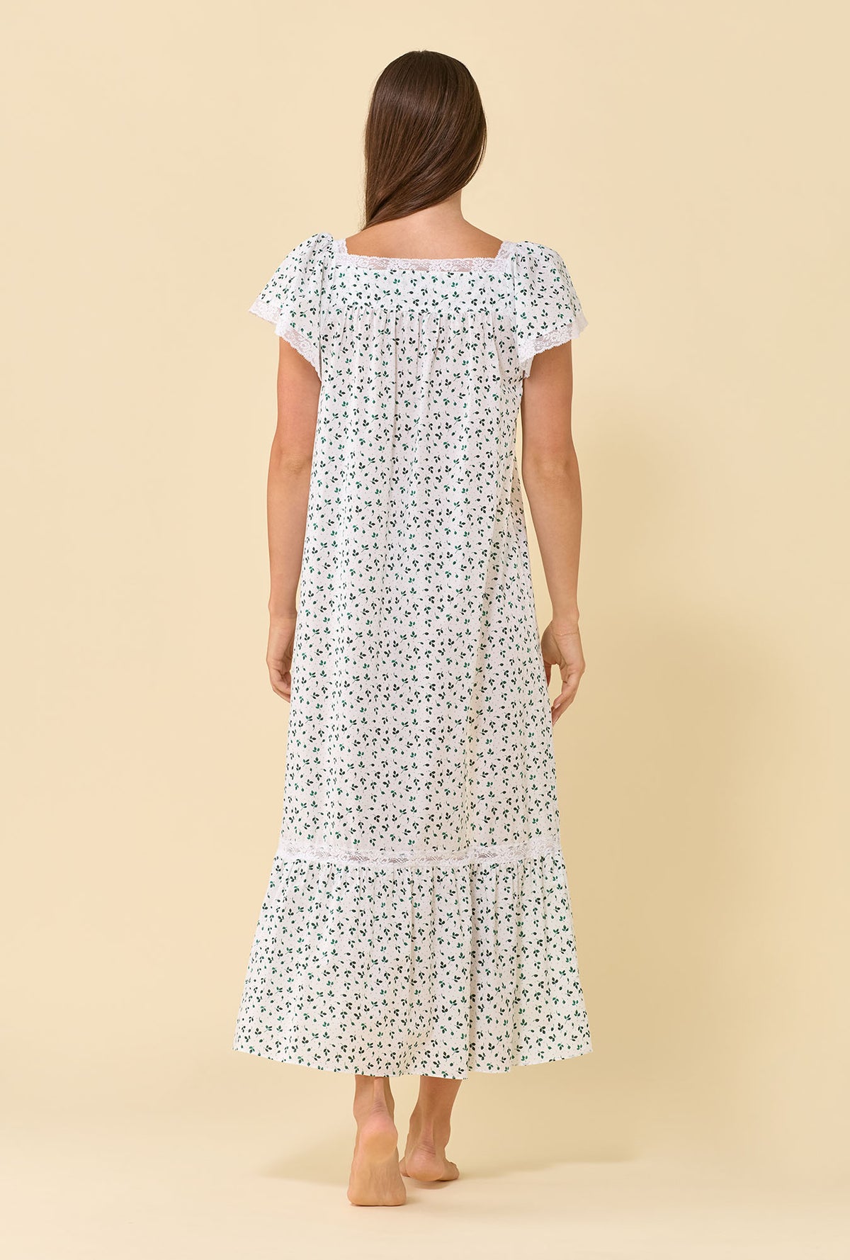 A lady wearing Grace Meadow Sage 100% Cotton Woven Lawn Flutter Sleeve Ballet Nightgown back view