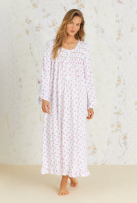 A lady wearing white long sleeve nightgown with vintage rose pointelle print.