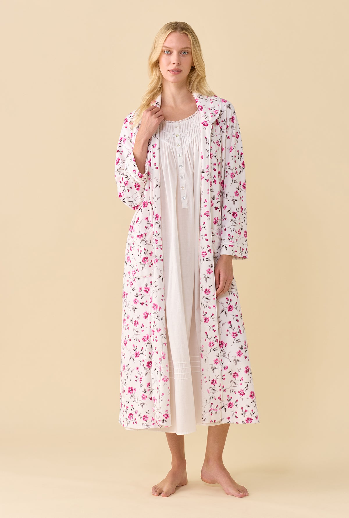 A lady wearing Lux Velour Ballet Zip Robe open over a white nightgown front view showing the pink floral print with one hand at the collar