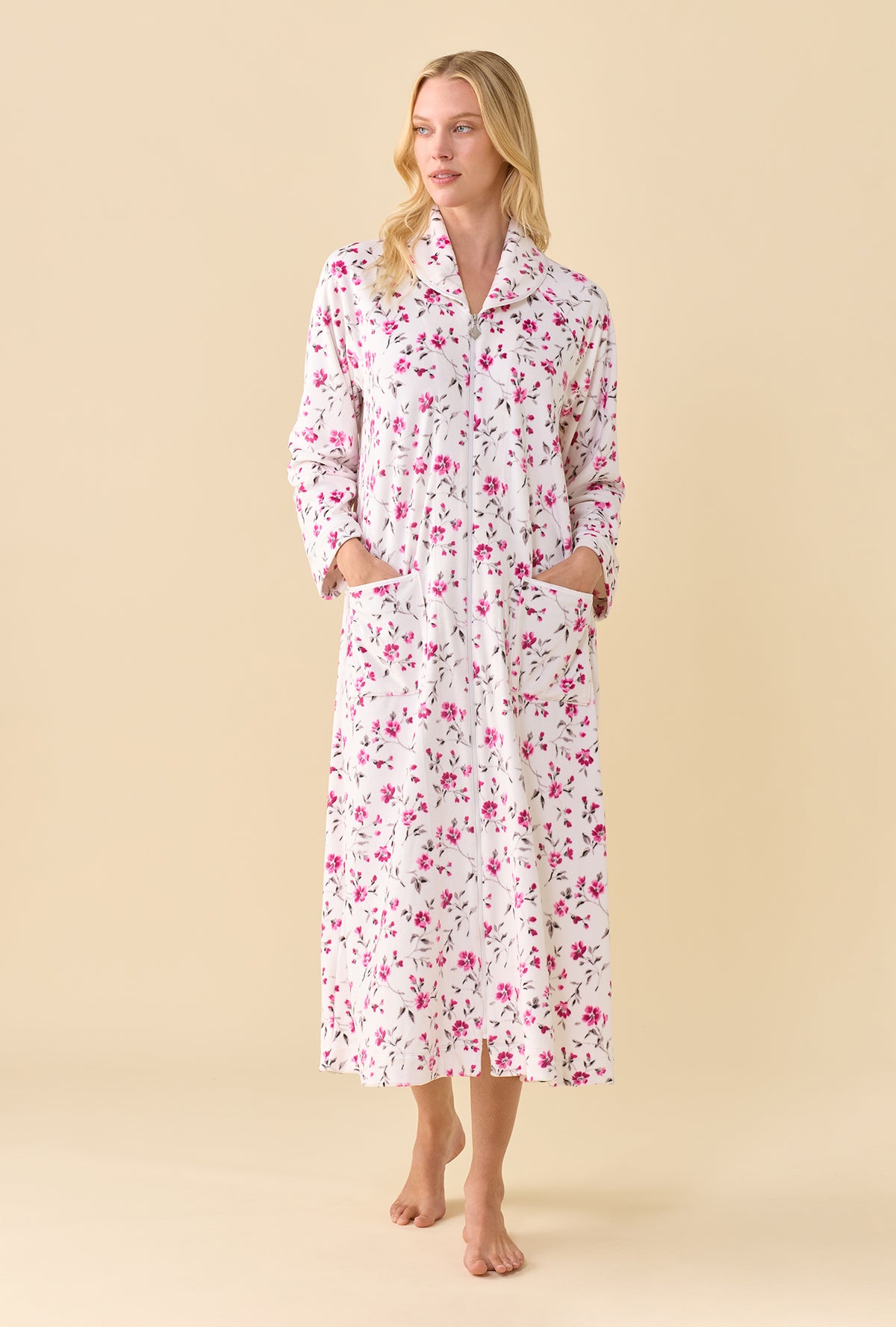 A lady wearing Lux Velour Ballet Zip Robe front view in pink floral print with both hands in patch pockets