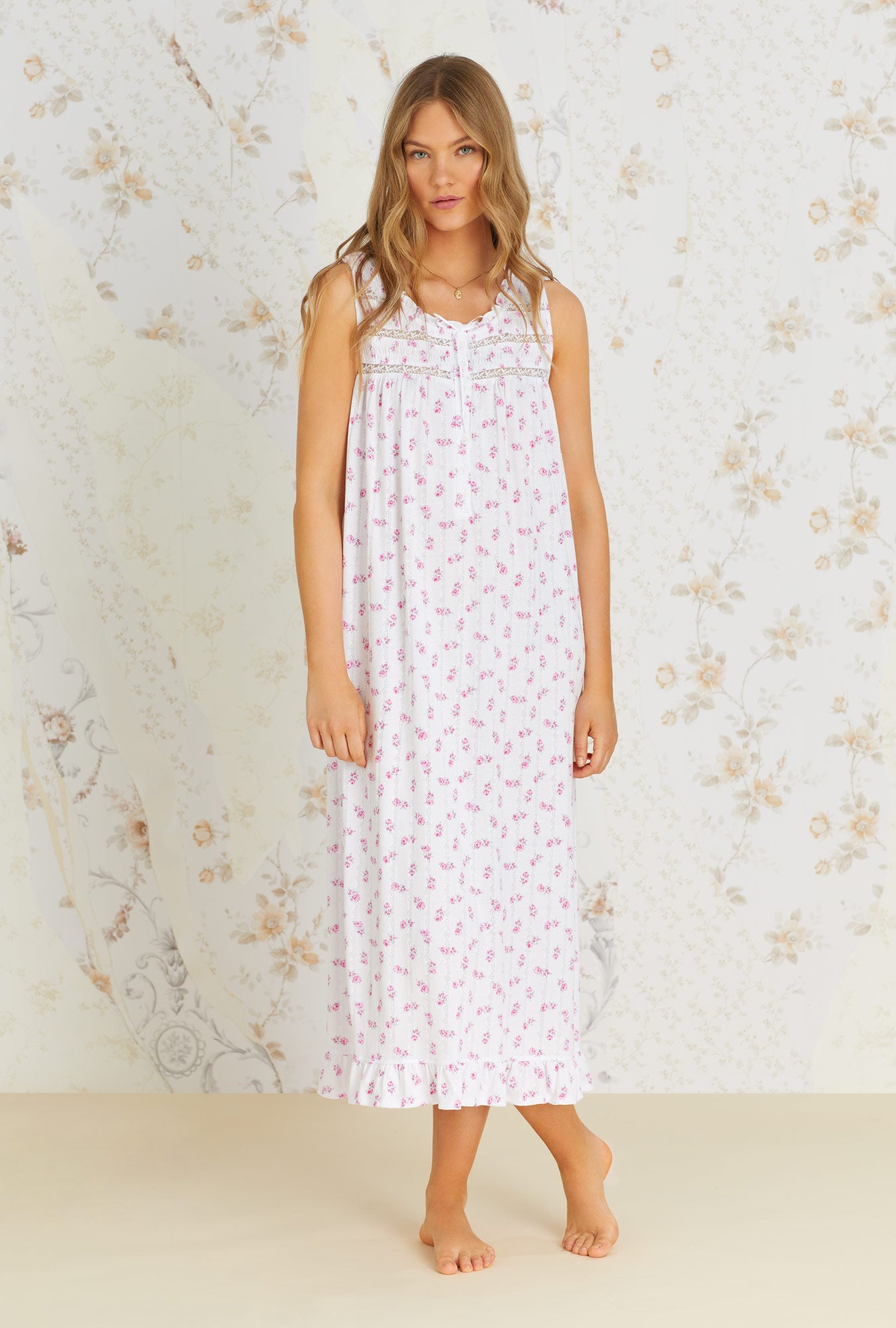 A lady wearing white sleeveless nursing nightgown with vintage rose pointelle print.
