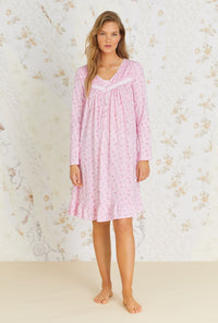 A lady wearing pink long sleeve short cotton knit nightgown with pink wildflower  print.
