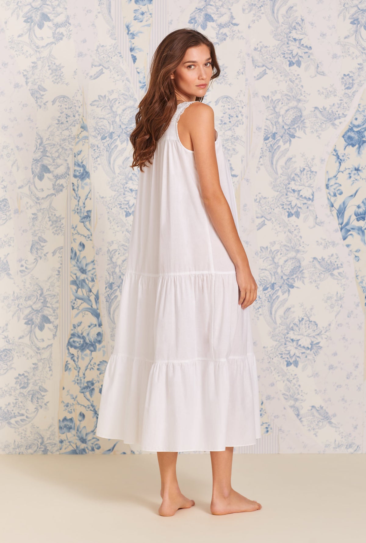 A lady wearing white sleeveless classic nightgown
