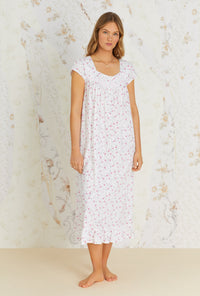 A lady wearing white cap sleeve long nightgown with trellis bloom print.