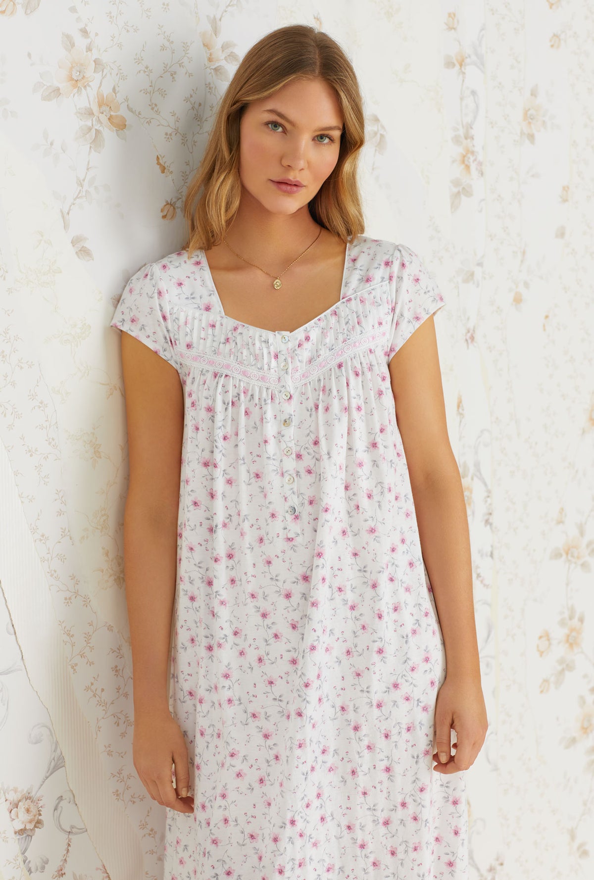 A lady wearing white cap sleeve long nightgown with trellis bloom print.