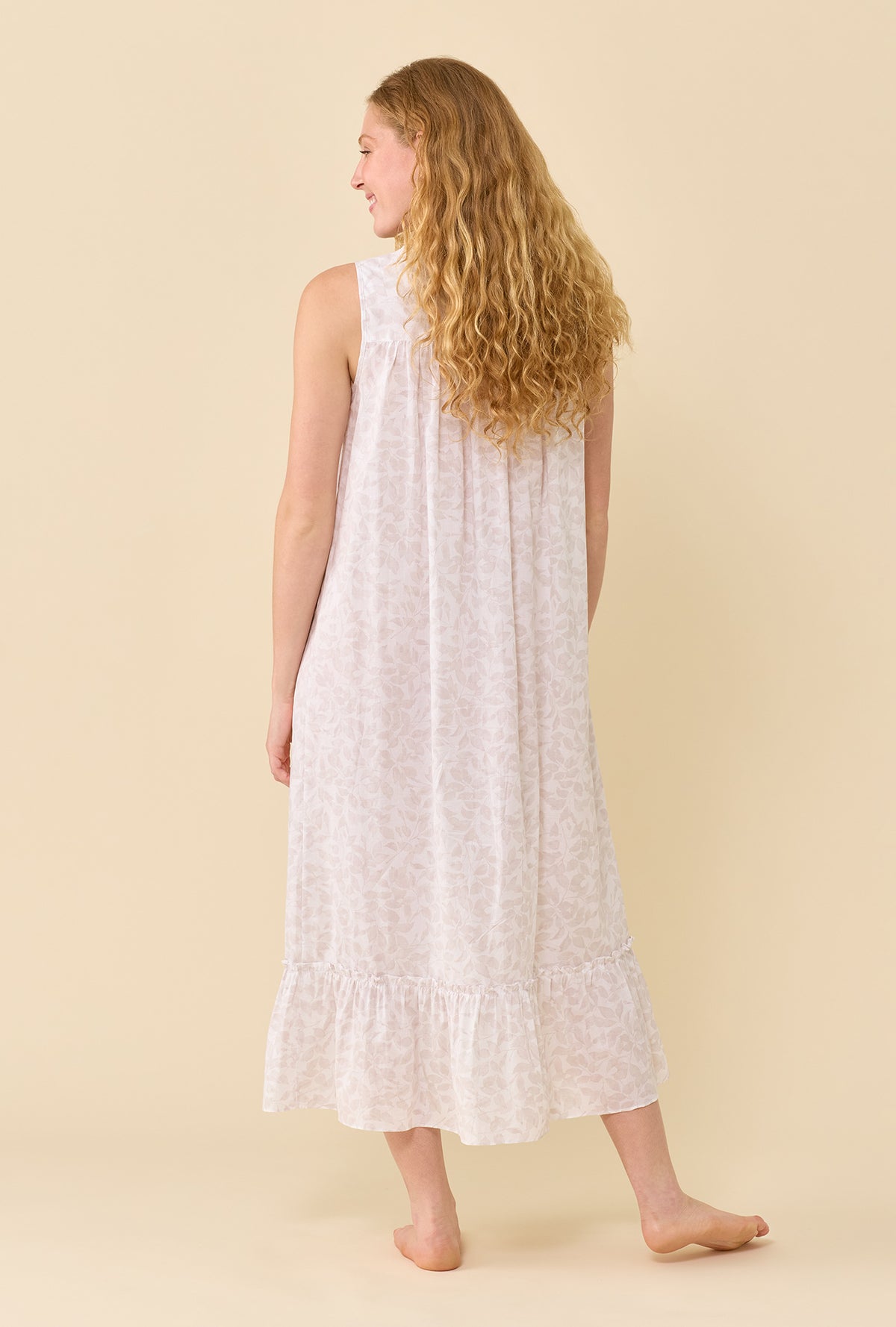 A Lady Wearing The Eileen Cottage Fern Nightgown facing back with a free hand pose