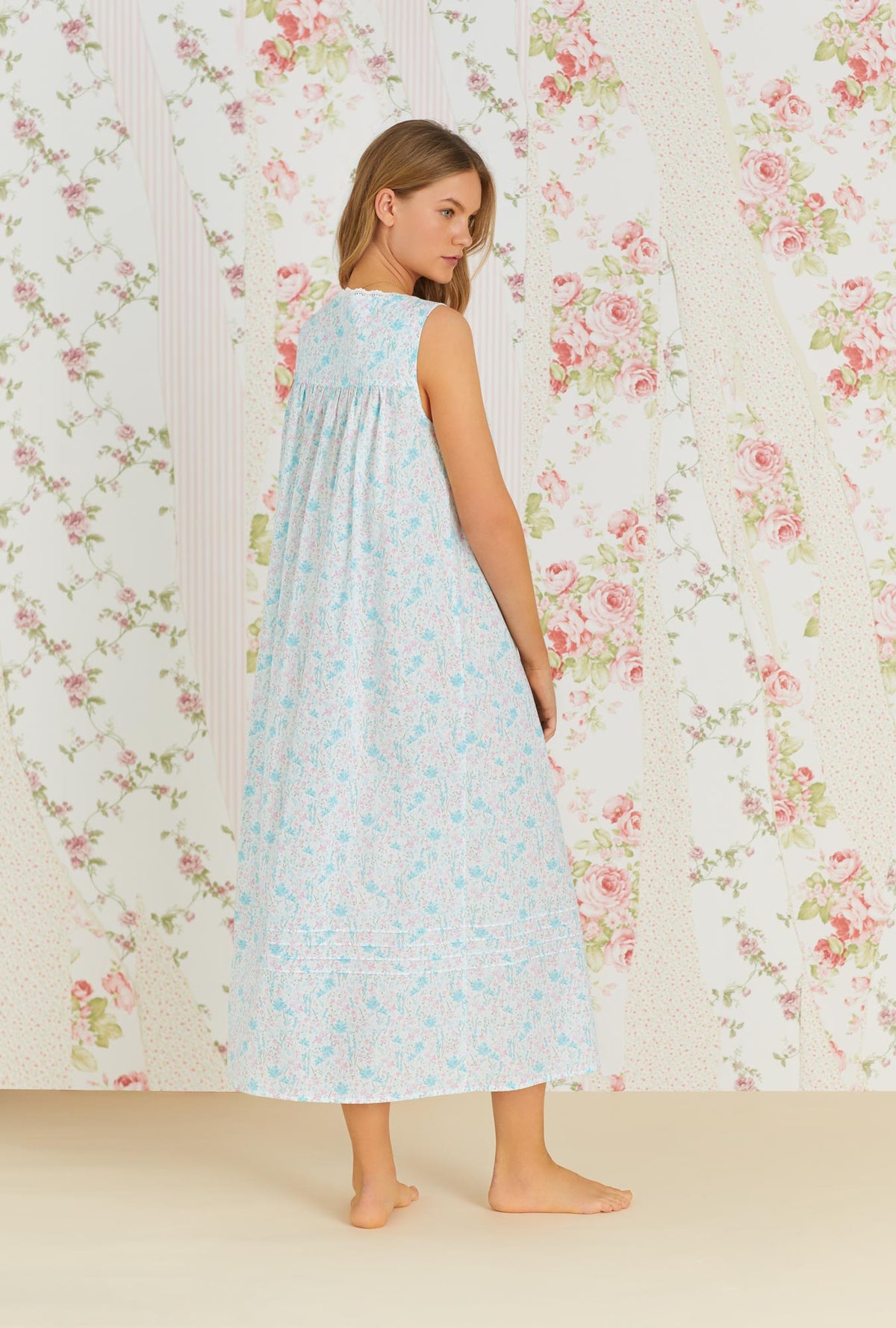 A lady wearing white sleeveless eileen cotton nightgown with tuolumne meadow print.