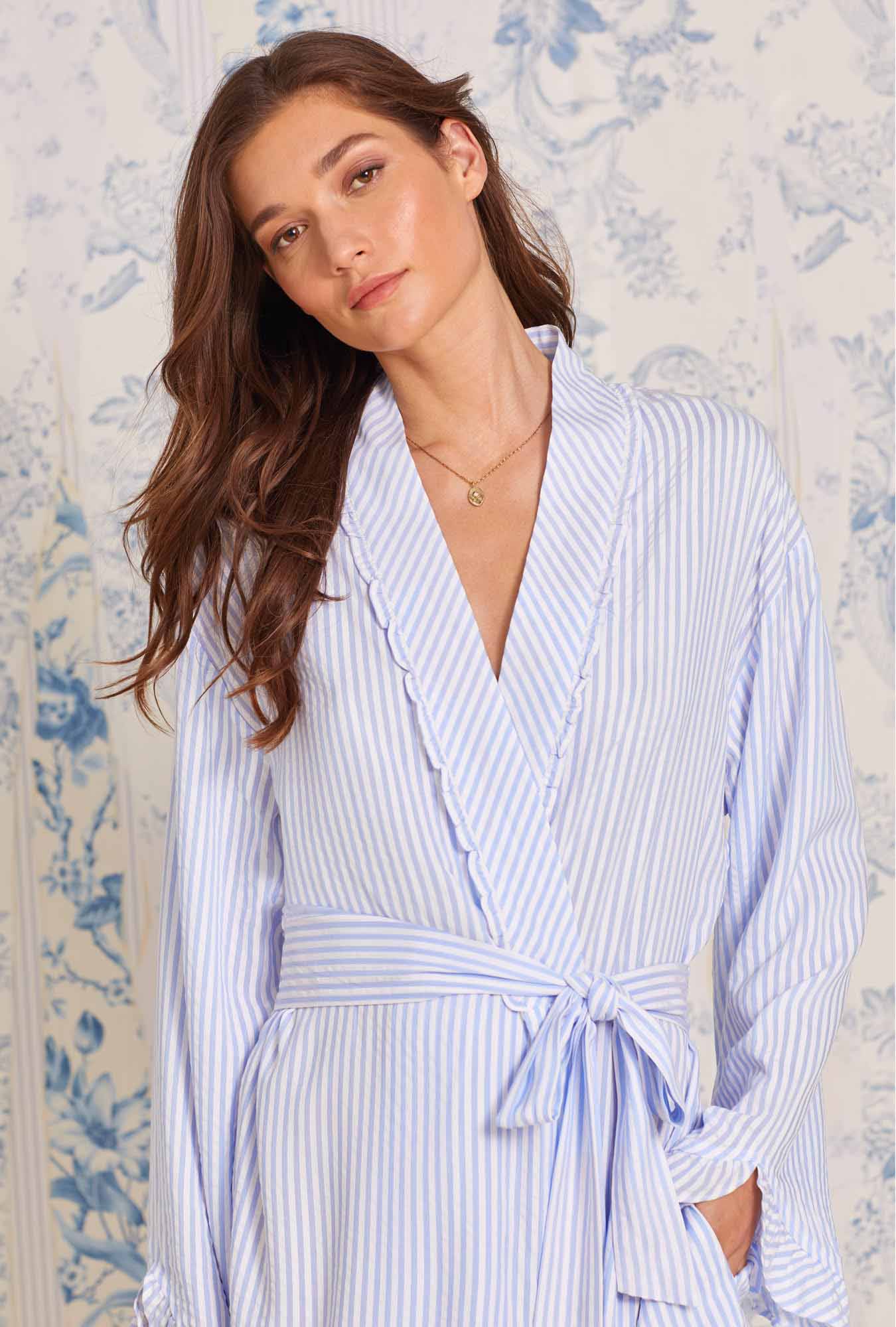 A lady wearing white robe with blue stripes