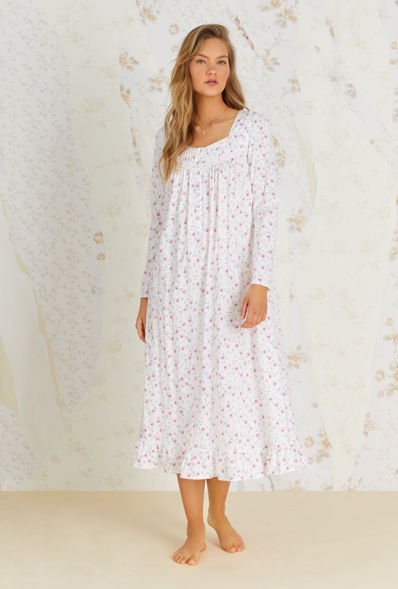 A lady wearing white long sleeve nightgown with trellis bloom print.