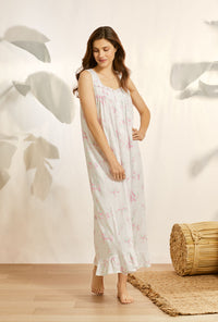 A lady wearing white sleeveless knit eileen nightgown with butterfly floral print.