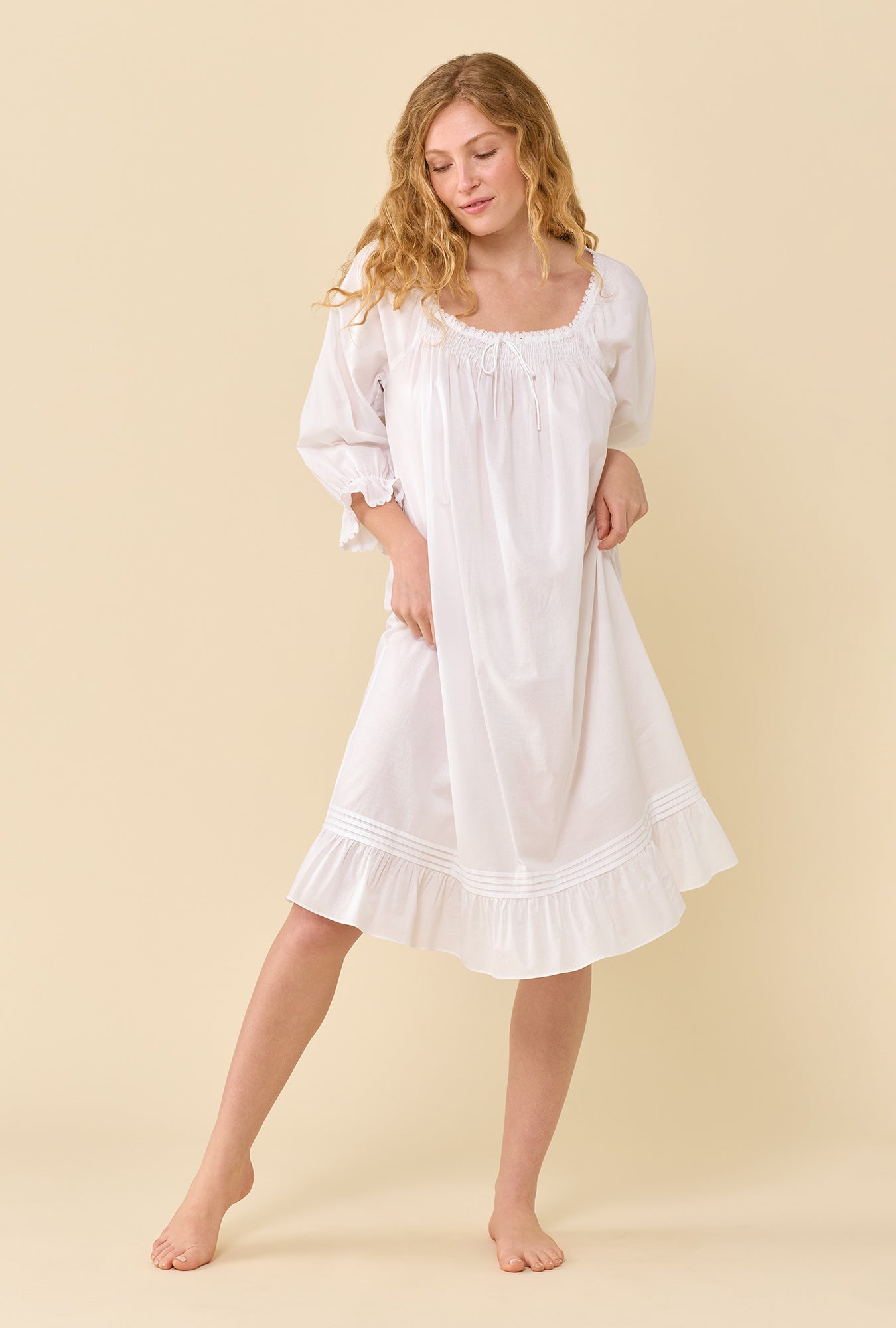 A lady wearing Iris Soft White 100% Cotton Woven Lawn 3/4 Sleeve Waltz Nightgown looking down
