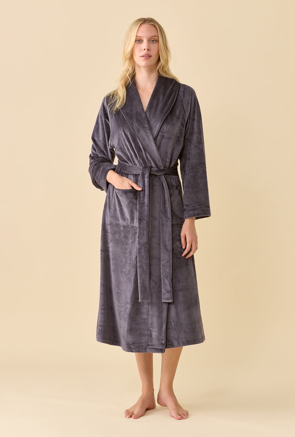 A lady wearing Lux Velour Long Wrap Robe front view with the belt tied and one hand in a patch pocket