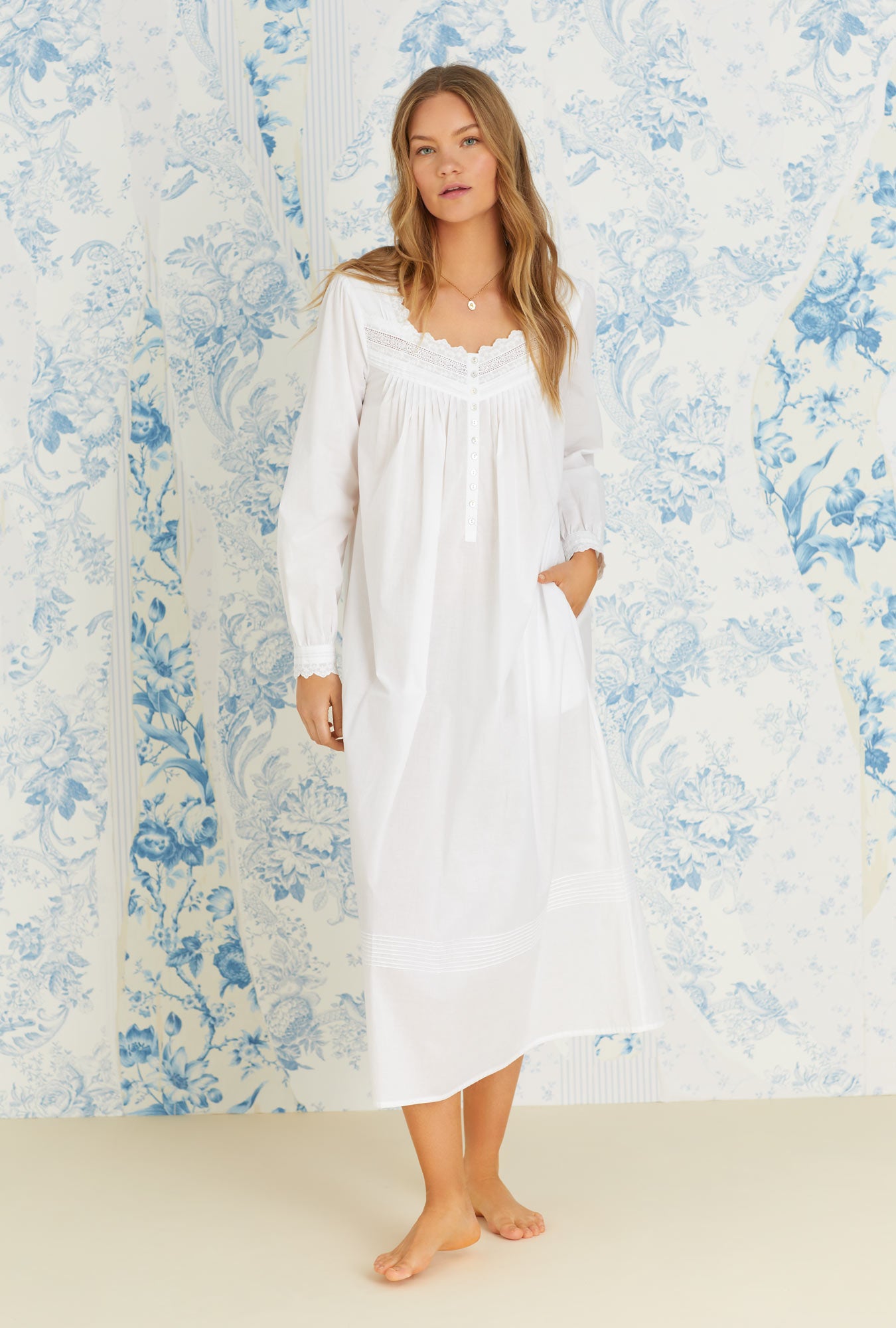 A lady wearing white long sleeve eileen cotton woven nightgown.