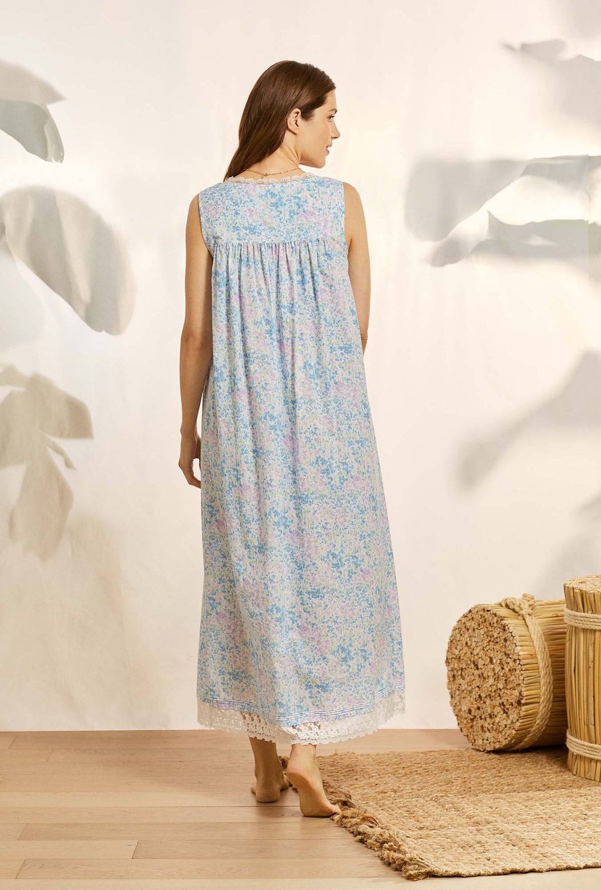 A lady wearing blue sleeveless eileen cotton nightgown with montara fields print.