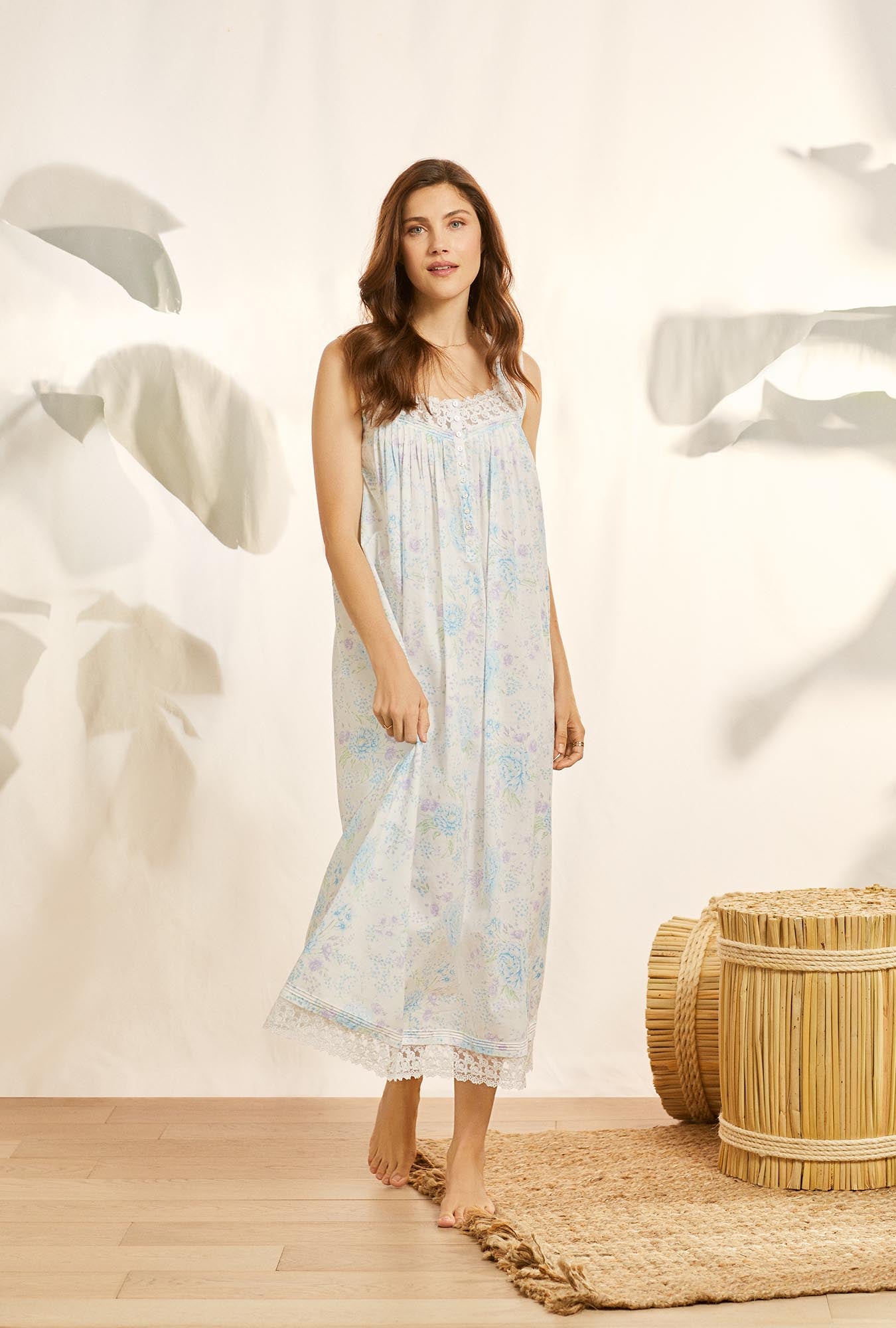 A lady wearing white sleeveless eileen cotton nightgown with summer garden print.