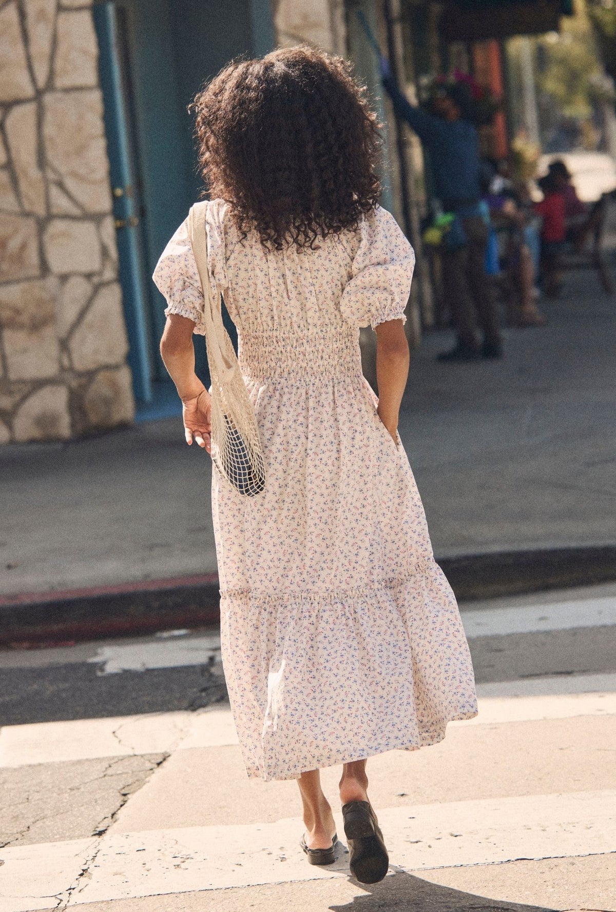 A lady wearing The "Marin" Buttercup Floral Cotton Maxi Dress back view