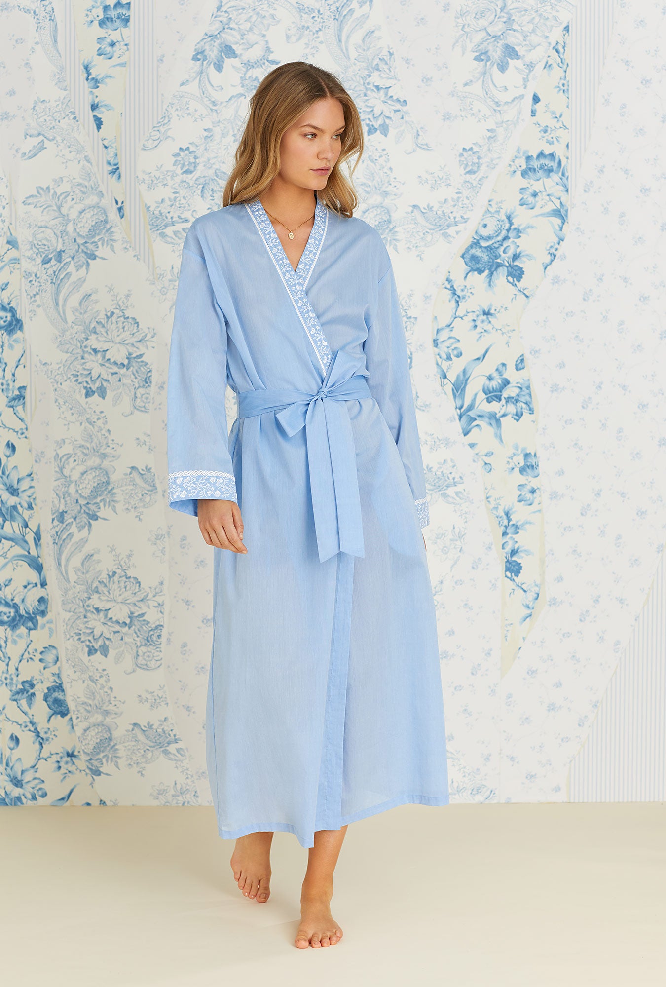 A lady wearing long sleeve blue cotton chambray long wrap robe.