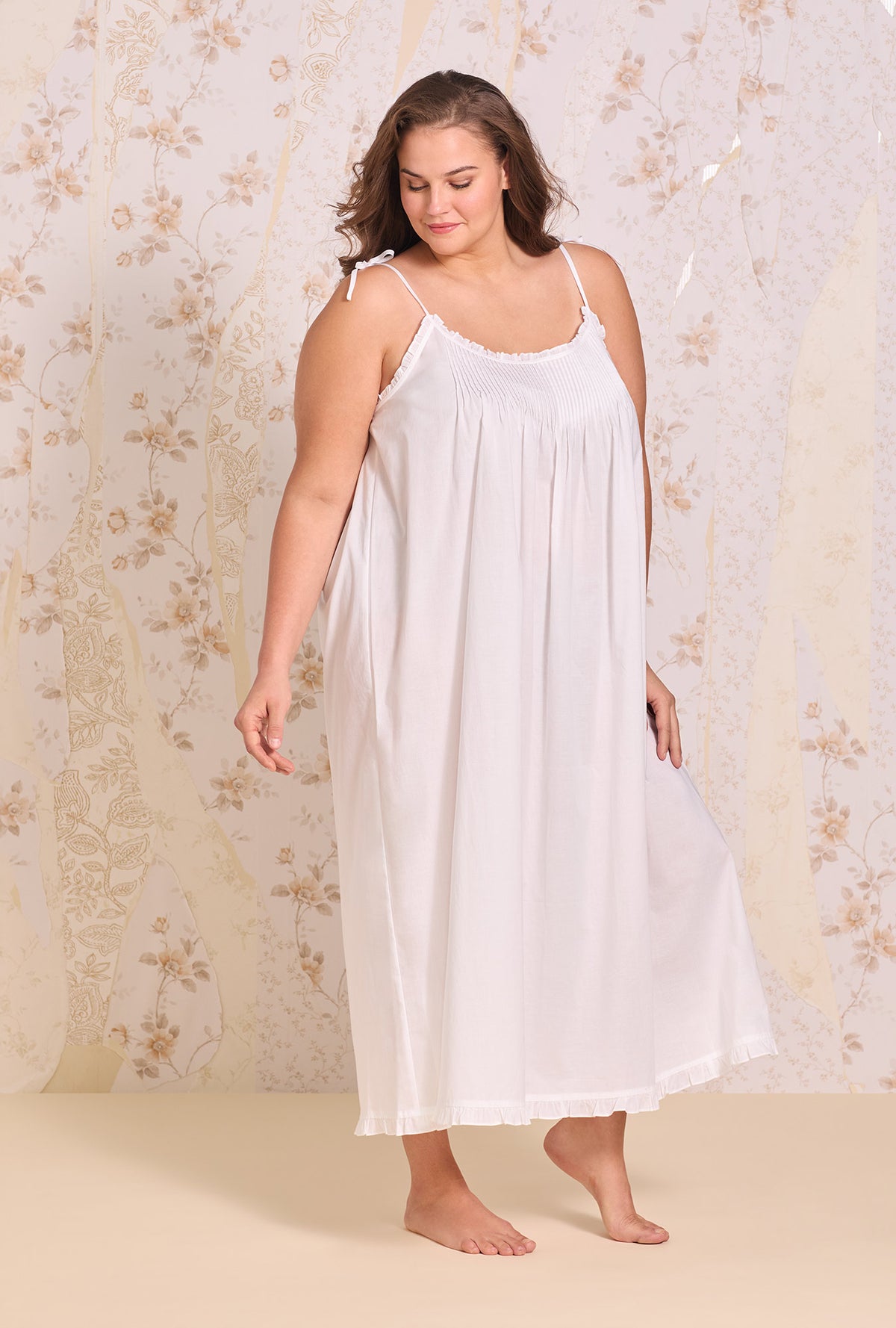 A lady wearing plus size The "Lucille" Iconic White Cotton Lawn Ballet Nightgown  looking down