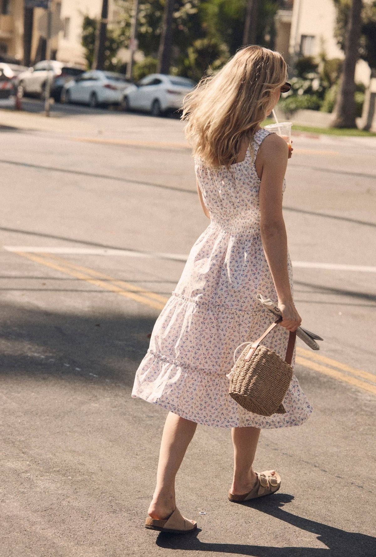 A lady wearing The "Nora" Buttercup Floral Cotton Midi Dress back view