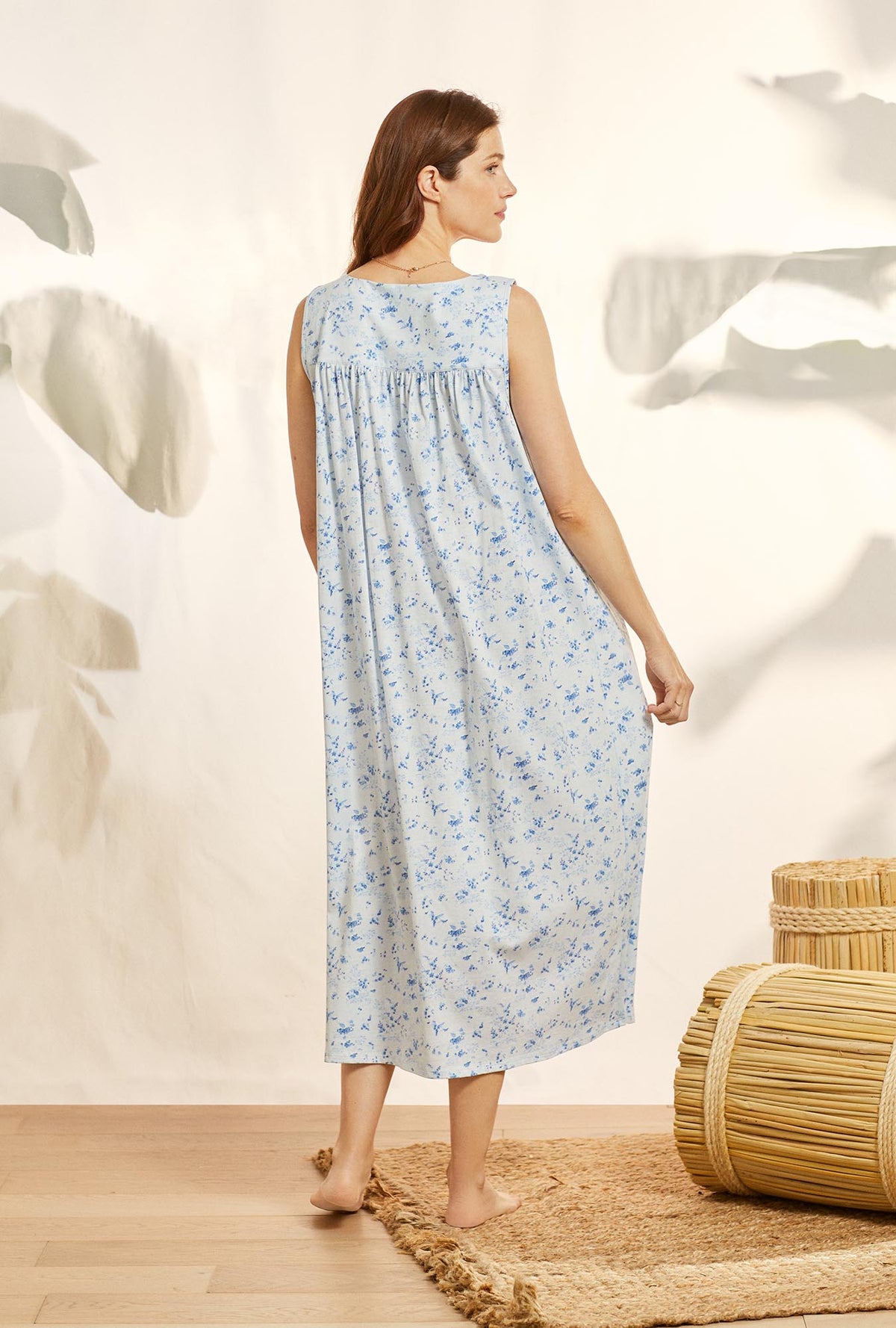 A lady wearing blue sleeveless cotton knit eileen nightgown with blue fields print.
