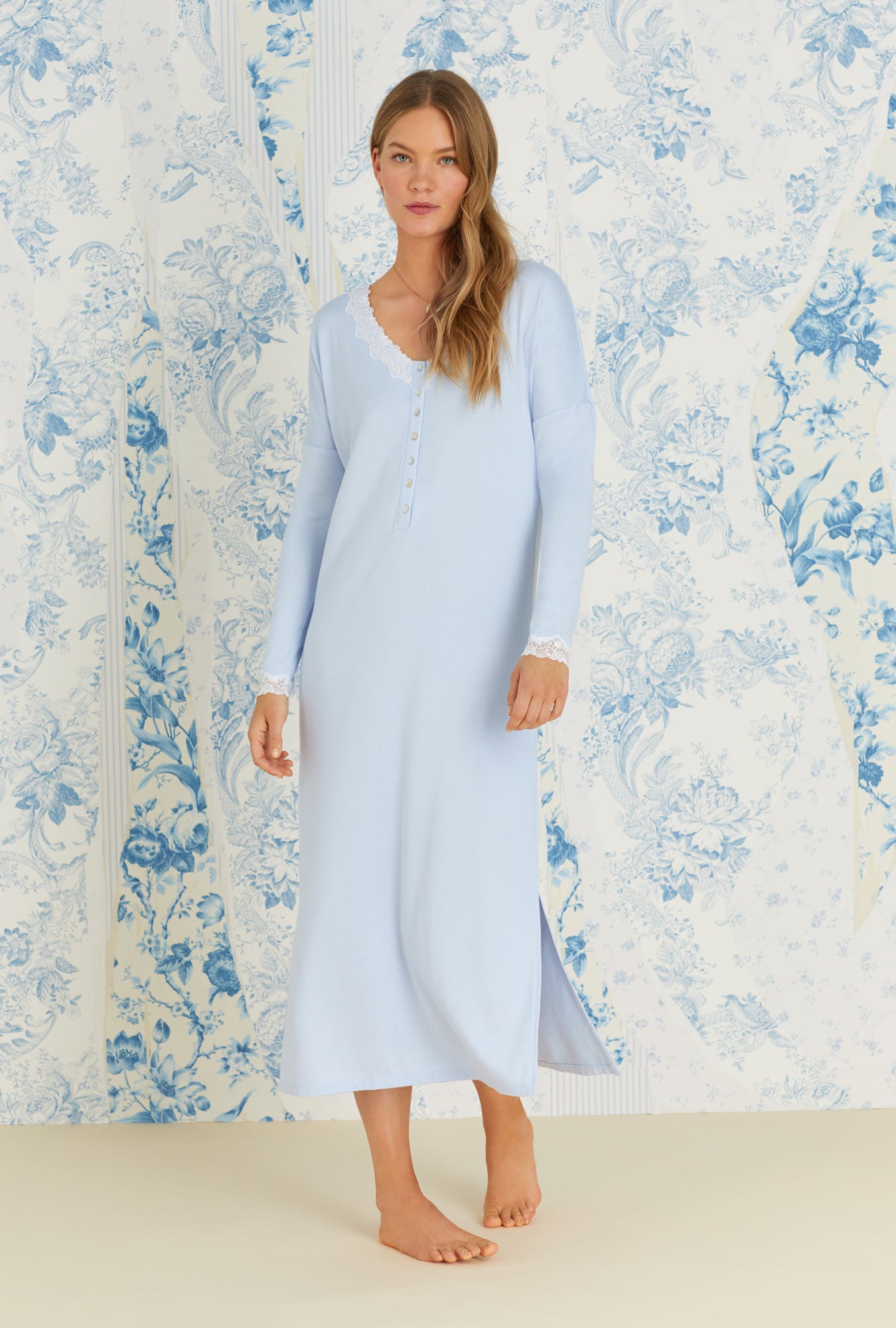 A lady wearing long sleeve blue cozy sweater knit long lounger nightgown.