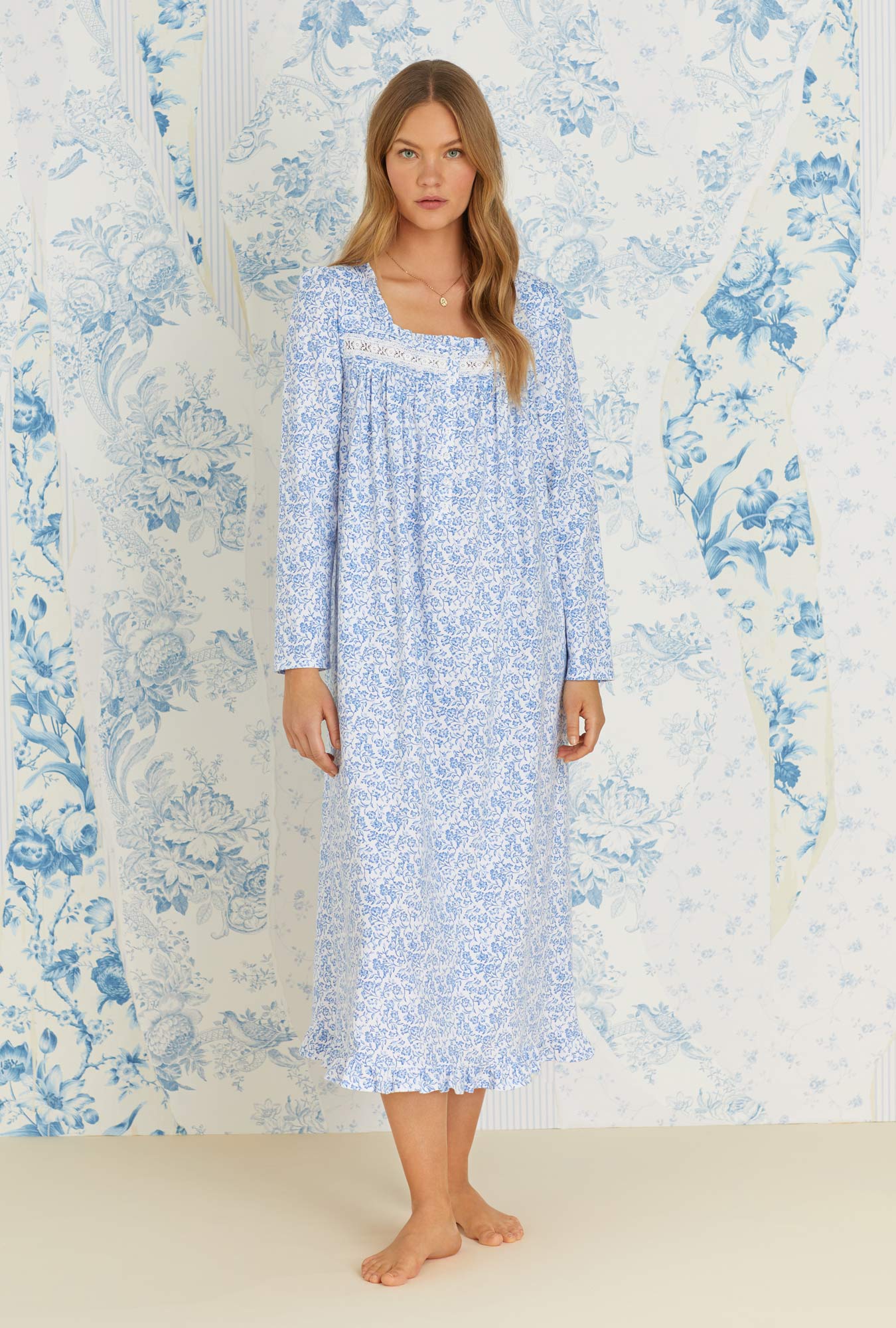 A lady wearing long sleeve blue scroll floral cotton knit long nightgown.