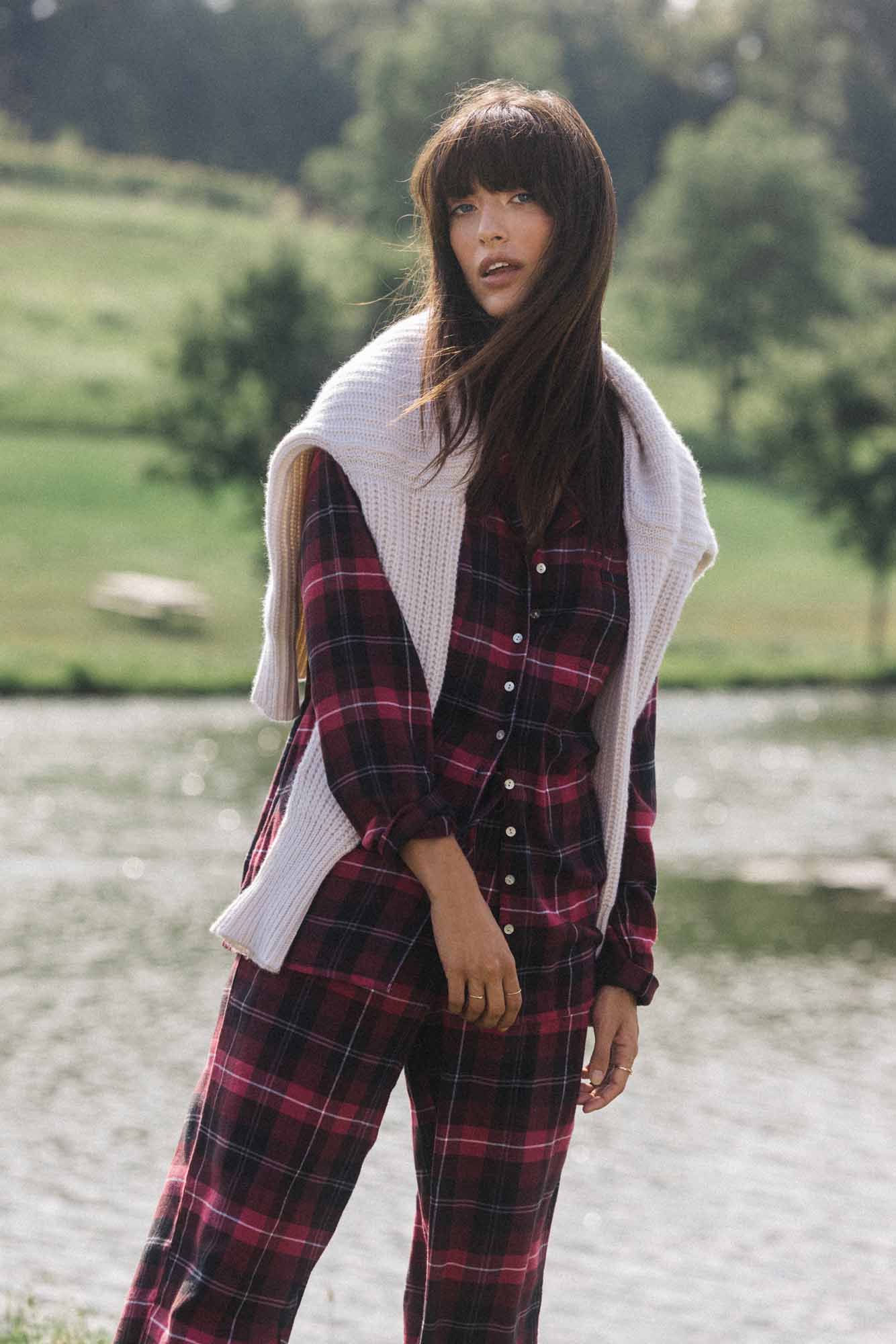 A lady wearing a holly berry plaid long sleeve rayon lightweight  flannel notch collar pajama.
