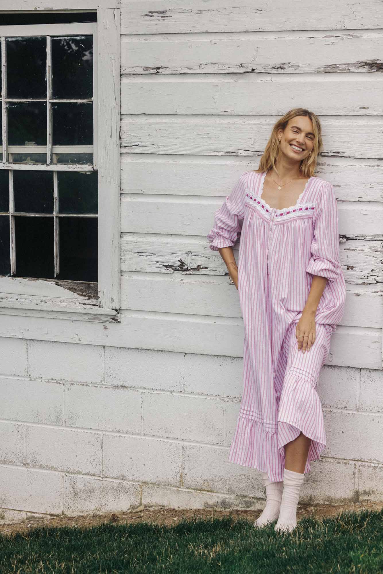 A lady wearing a candy stripe long sleeve rayon lightweight flannel long nightgown.