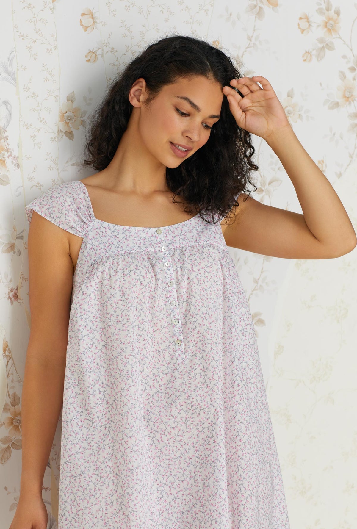 A lady wearing white cap sleeve cotton waltz nightgown with kayla baby rosette print.
