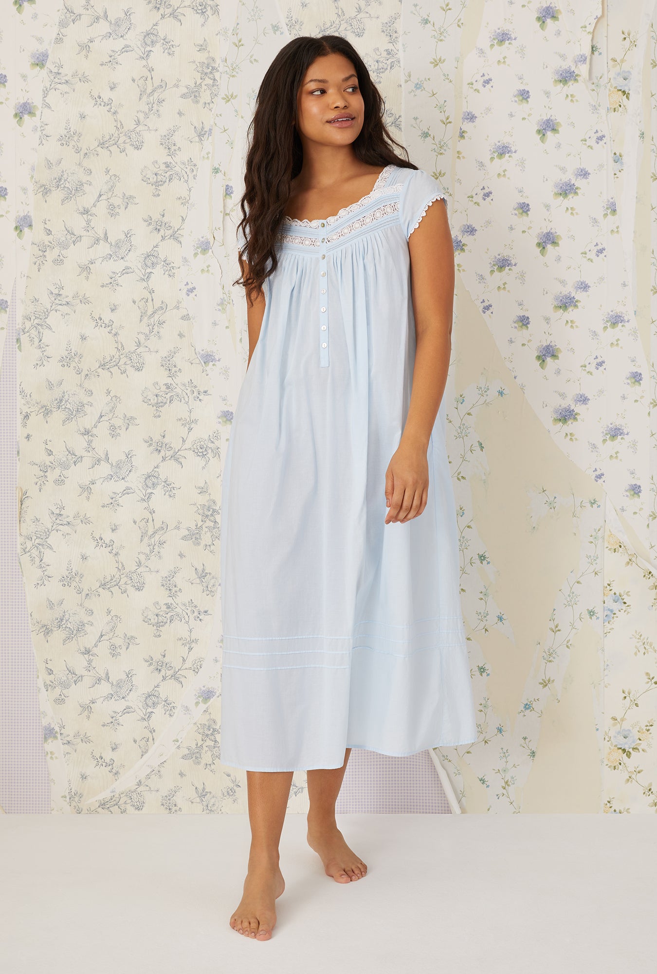 A lady wearing a white cap sleeve gown.