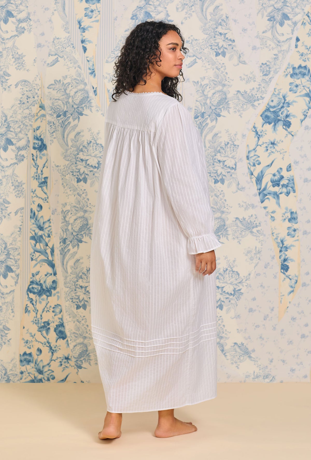 A lady wearing a pink dobby stripe long sleeve button front robe.
